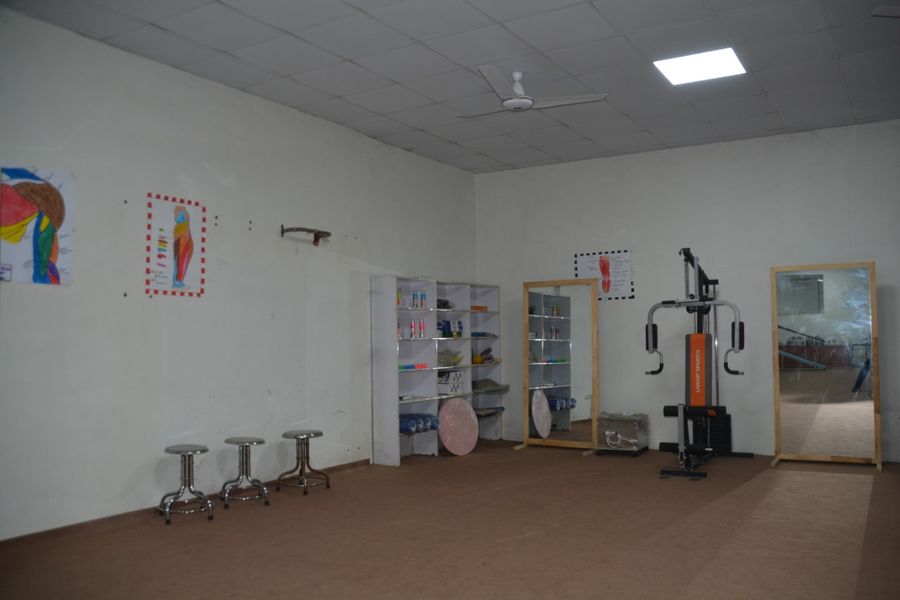 Physiotherapy practice room at Royal Institute, Lahore, with exercise equipment, mirrors and anatomy charts